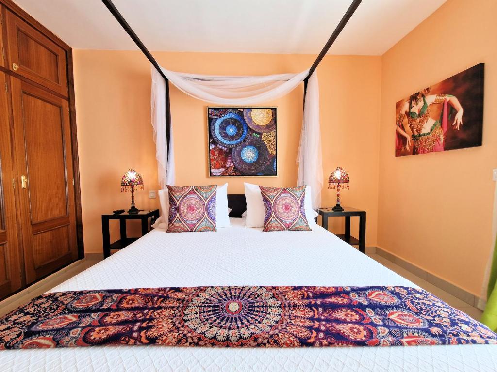 塞博河畔卡莱塔Suite Marrakech Beach, La Graciosa.的一间卧室配有一张床和两盏灯。