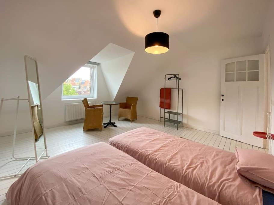 迪克斯梅德Kleine Dijk的一间卧室配有一张床、一张桌子和一个窗户。