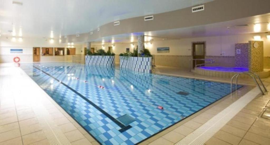 斯莱戈斯莱戈克莱顿酒店及休闲俱乐部的大楼内一个蓝色瓷砖的大型游泳池