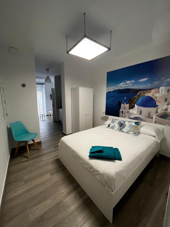 巴达霍斯APARTAMENTOS MAPAMUNDI的一间卧室配有一张大床,上面有蓝色的毛巾