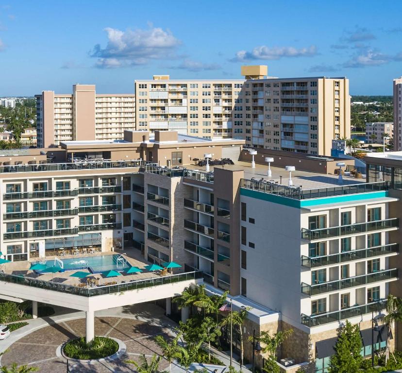 帕诺滩Tru By Hilton Pompano Beach Pier的享有带游泳池的建筑的空中景致