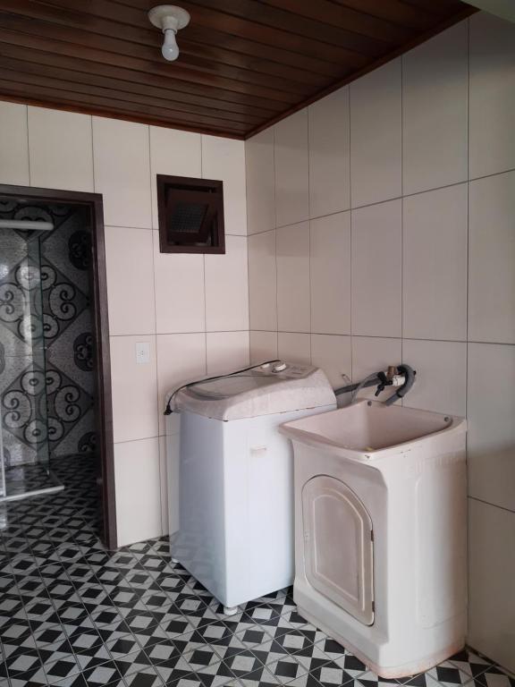 托雷斯Apartamento com pátio e anexo exclusivo的一间带洗衣机和卫生间的浴室
