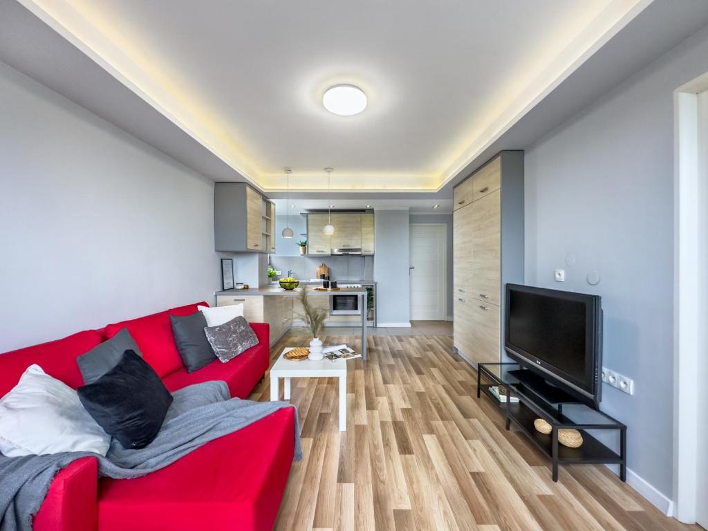 克拉科夫Apartament z widokiem na panoramę miasta的客厅配有红色沙发和电视