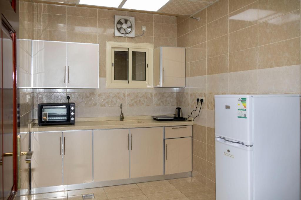 麦地那غزالي للوحدات السكنية的厨房配有白色橱柜和白色冰箱。