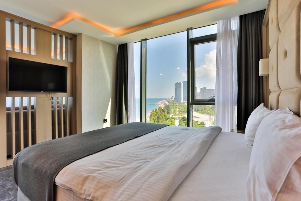巴统Batumi View Luxury的一间卧室设有一张大床和大窗户