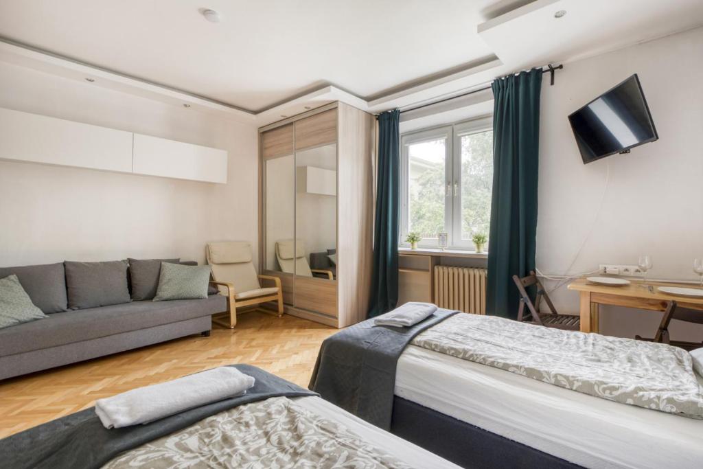 华沙Labo Apartment Ogrodowa的一间带两张床和一张沙发的客厅