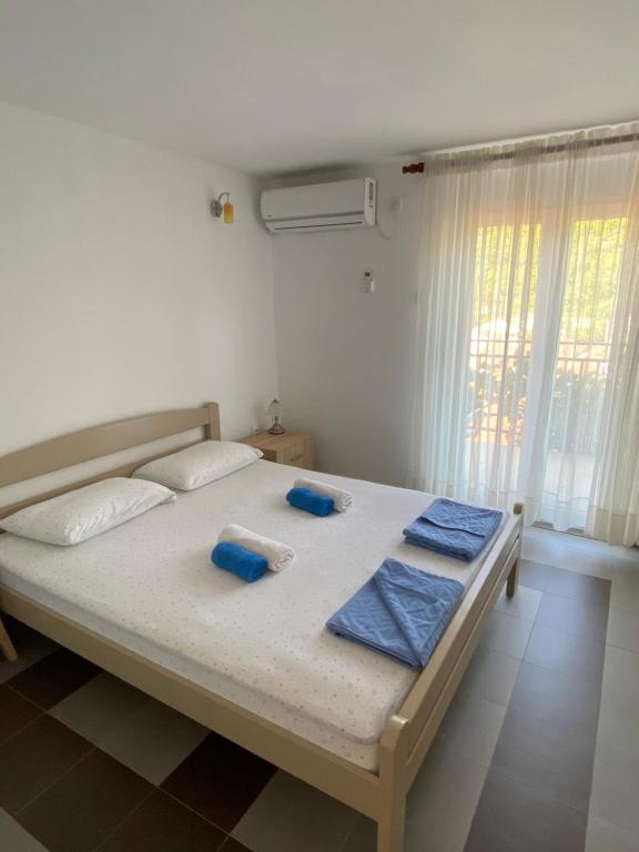 DodošiLotus House Dodoši的一间卧室配有一张带蓝色毛巾的床