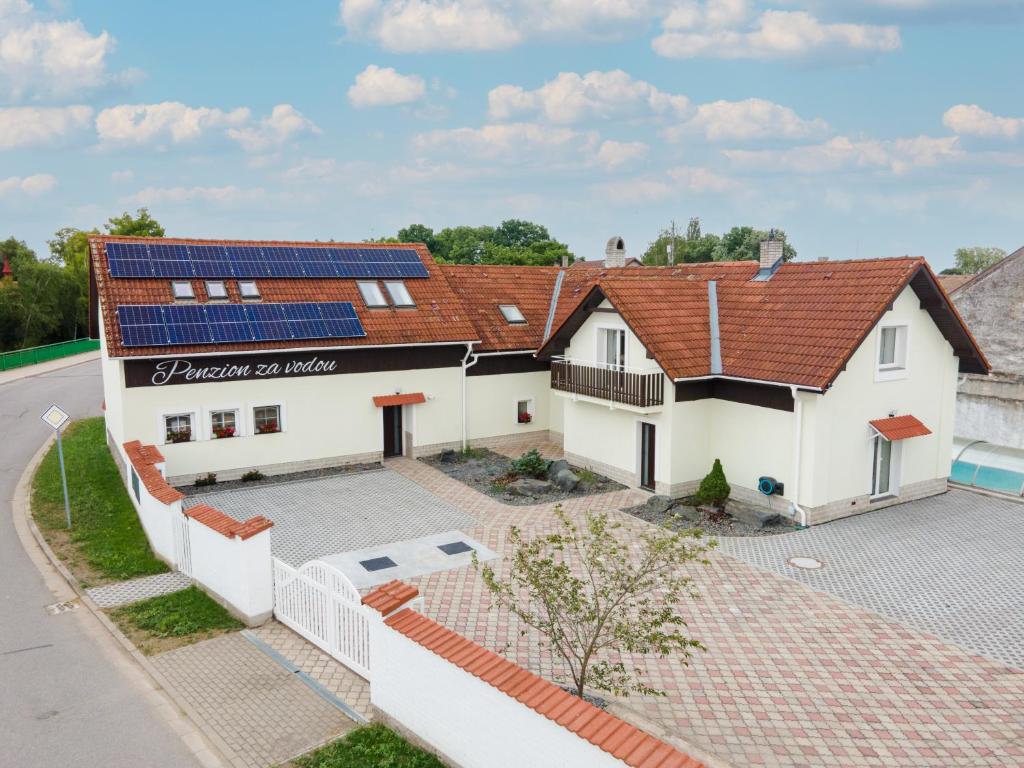 SezemicePENZION ZA VODOU的屋顶上太阳能电池板房子的空中景观