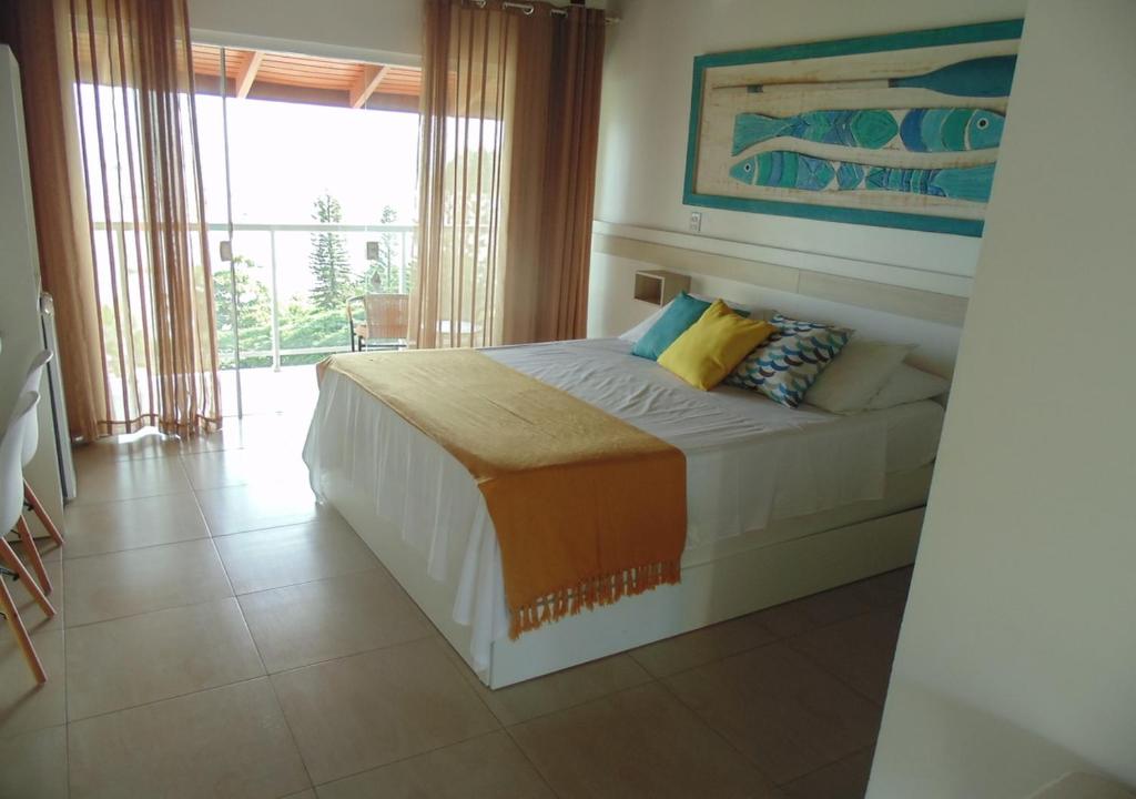 佩尼亚Hotel Maricá的一间卧室设有一张床和一个大窗户