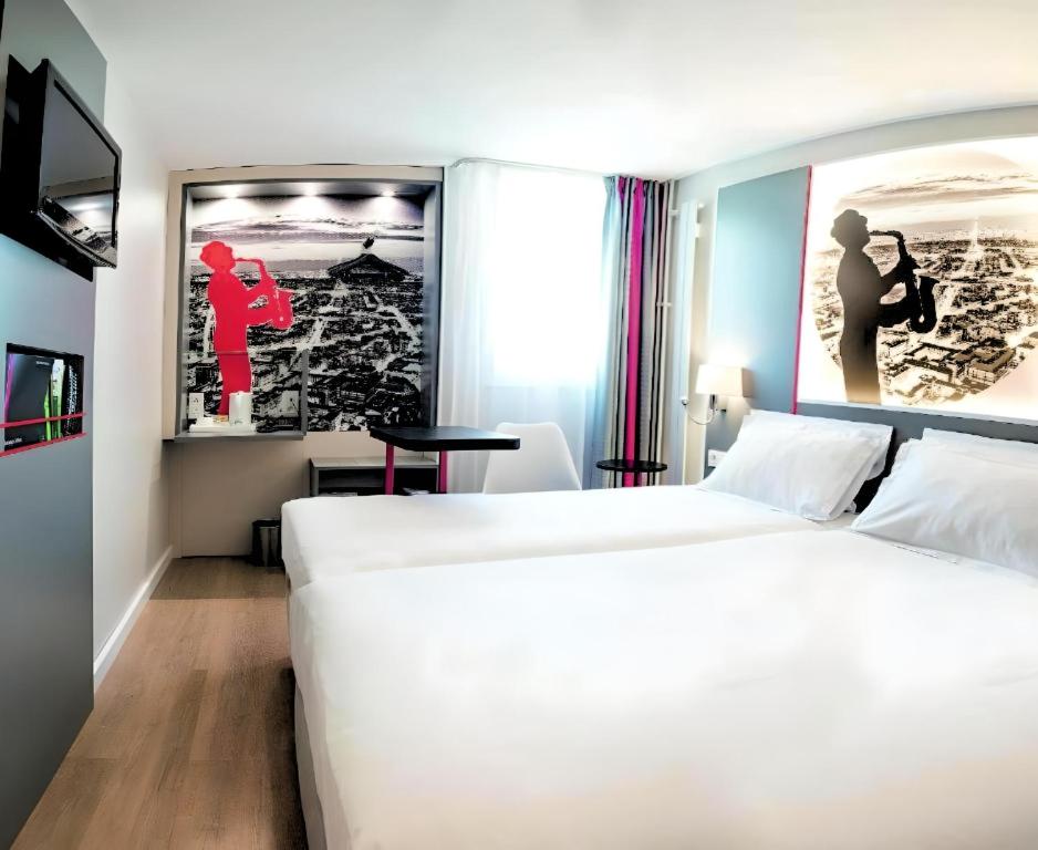 圣旺Kyriad Paris Saint Ouen的酒店客房设有两张床,墙上挂着一张照片。