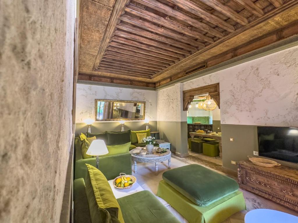 马拉喀什Maison Maria Palmeraie的客厅配有绿色椅子和桌子