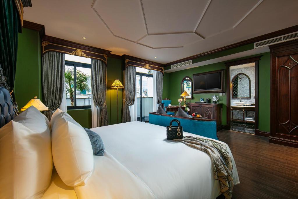 河内Le Chanvre Hanoi Hotel & Spa的卧室配有白色大床和绿色墙壁