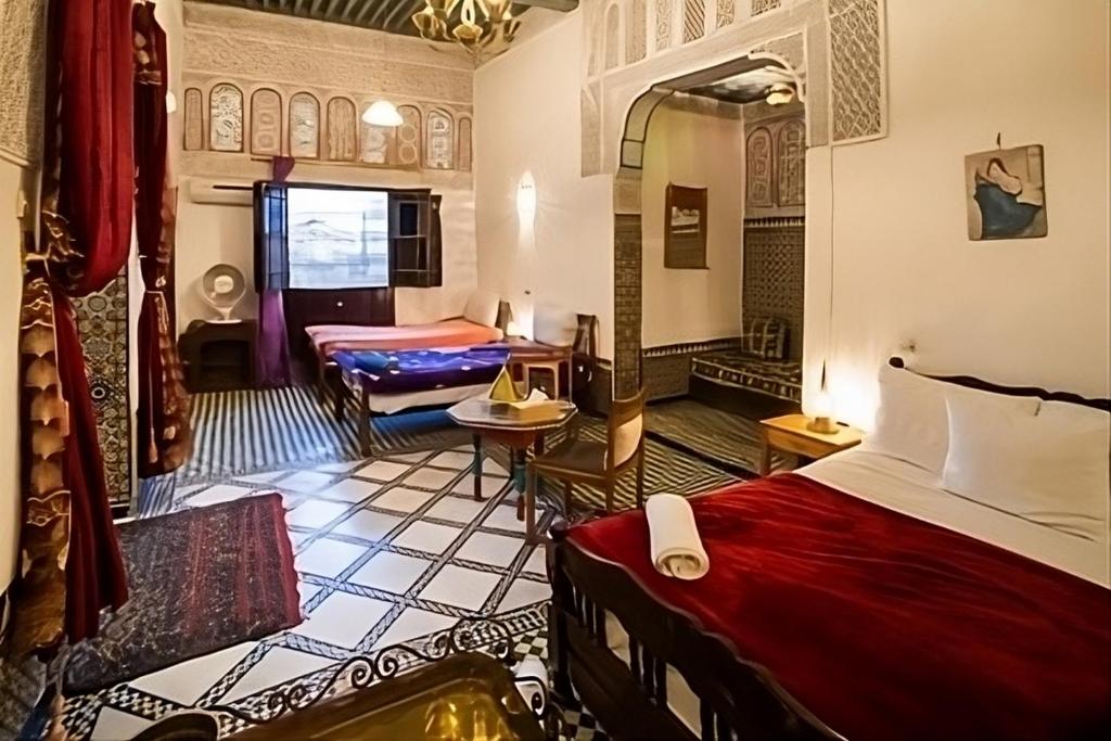 非斯Fes Antique Hostel的酒店客房,设有两张床和一张沙发