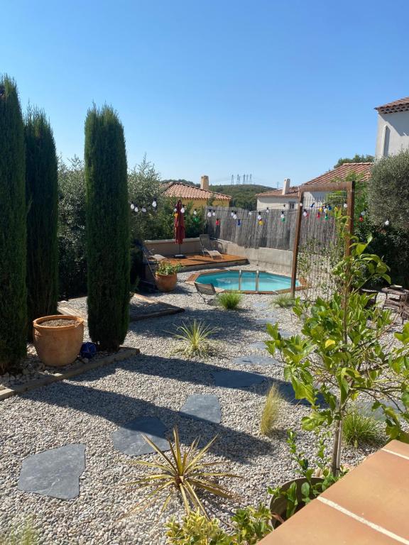 塞普特梅斯·莱瓦隆Studio entre Aix en Provence et Marseille et parking的一个带游泳池、树木和围栏的花园