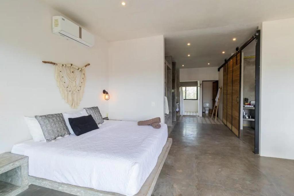 图卢姆Casa Macarena Loft 1-BR Escape Near Downtown的卧室设有一张白色大床和一个走廊