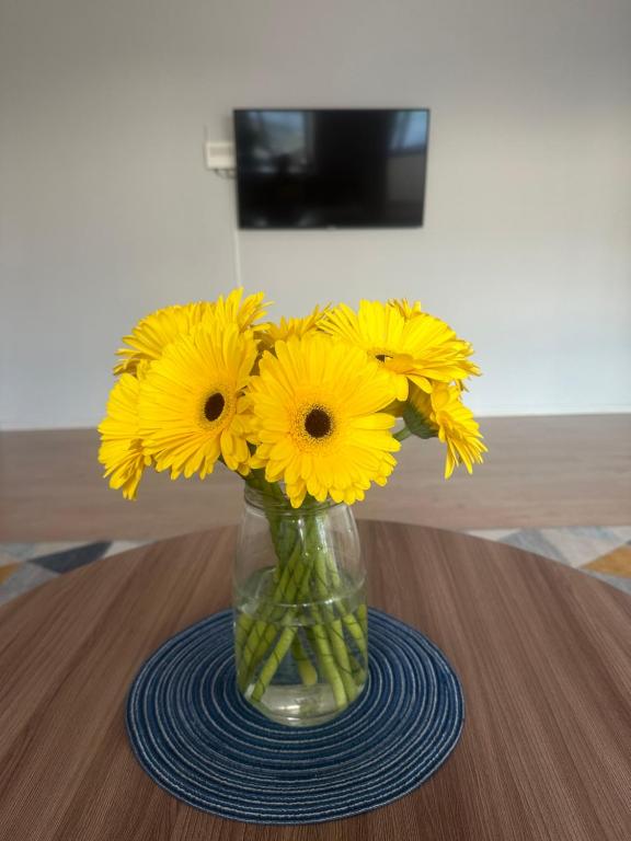 乌拉尔斯克Уютная и комфортная 3х комнатная в новом центре的花瓶,上面有黄色的花朵