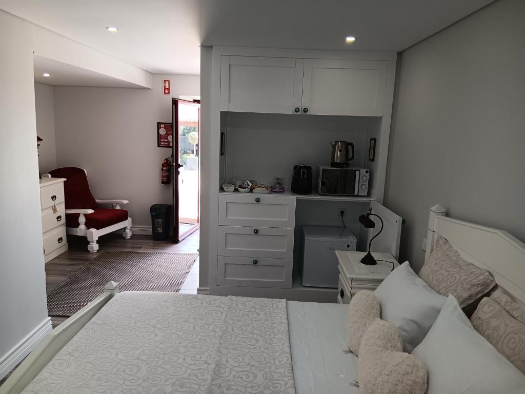 蓬德利马Casa d'Artengo的一间带一张床和一张书桌的卧室和一间厨房
