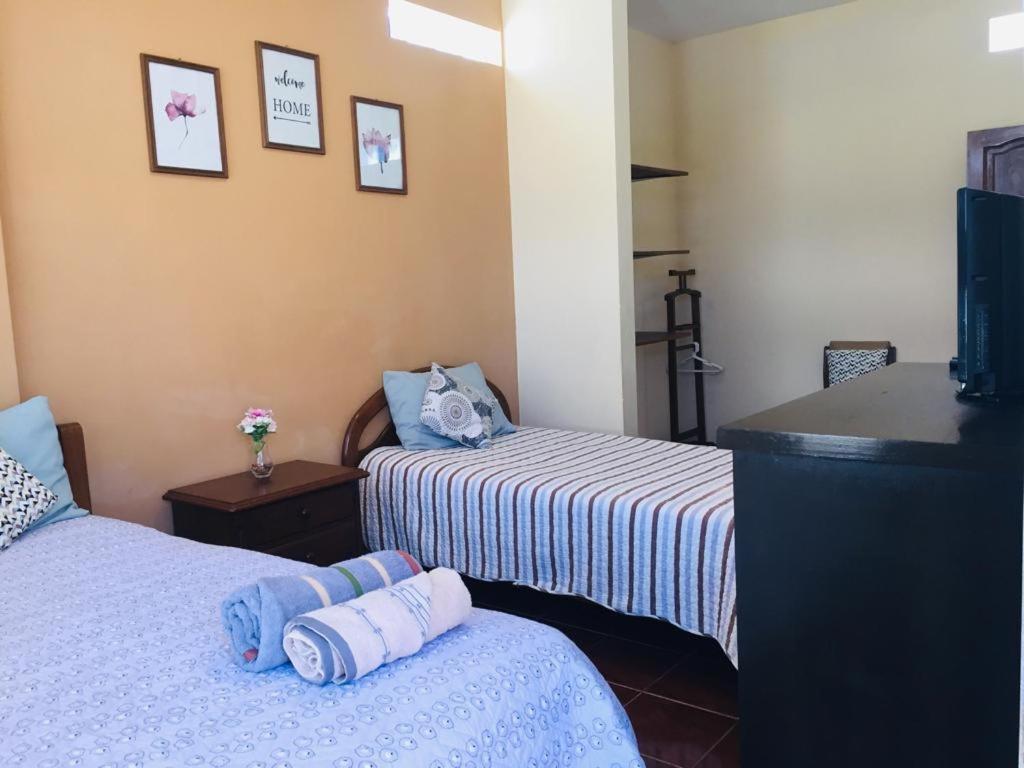 科恰班巴Bonita casa acogedora的酒店客房设有两张床和电视。