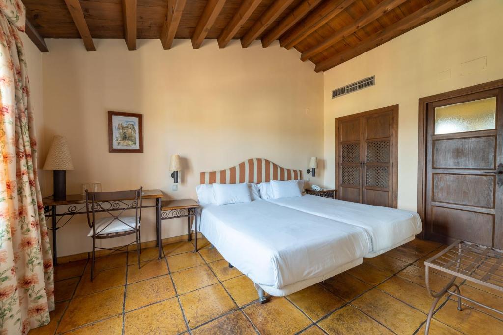 托莱多奇加拉尔卡拉瓦特斯酒店的卧室配有一张白色大床和一张书桌
