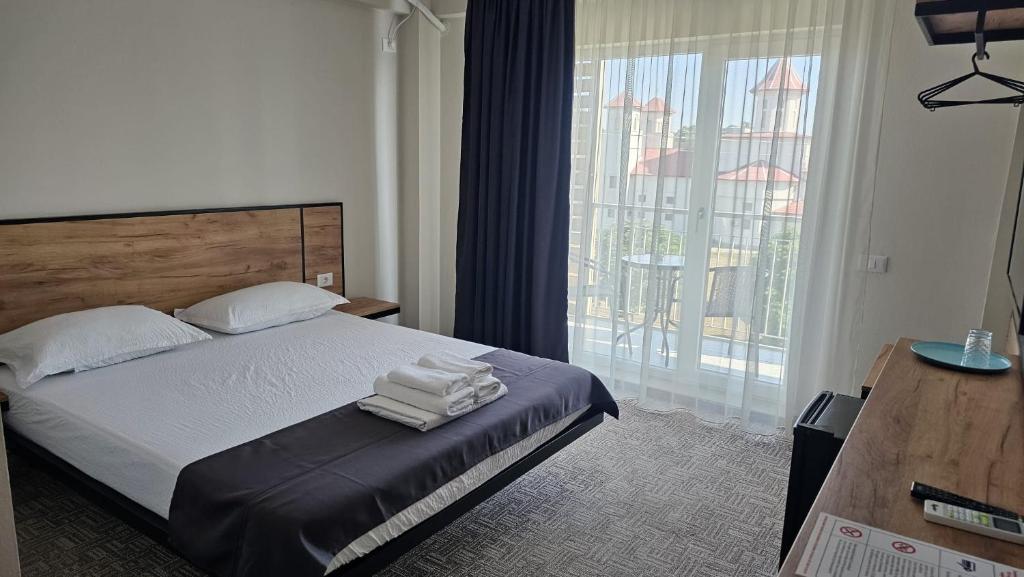 科斯蒂内什蒂ALYA Sea Escape Costinesti - parcare gratuita的酒店客房,配有带毛巾的床