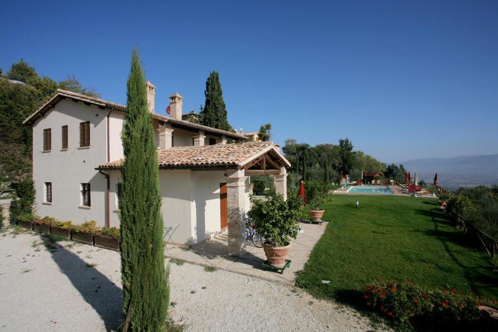 蒙特法尔科Casa Vacanze Vecciano的白色的房子,设有院子和游泳池