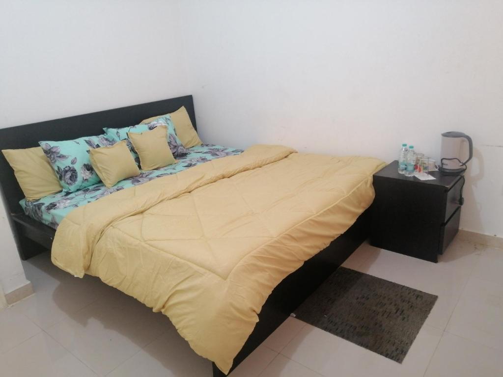 阿布扎比ETAS Residence的卧室配有一张带黄色床单和枕头的大床。