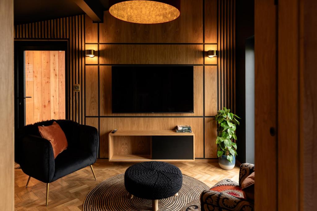 奥本The Black Cabin Oban的一间带电视和椅子的客厅