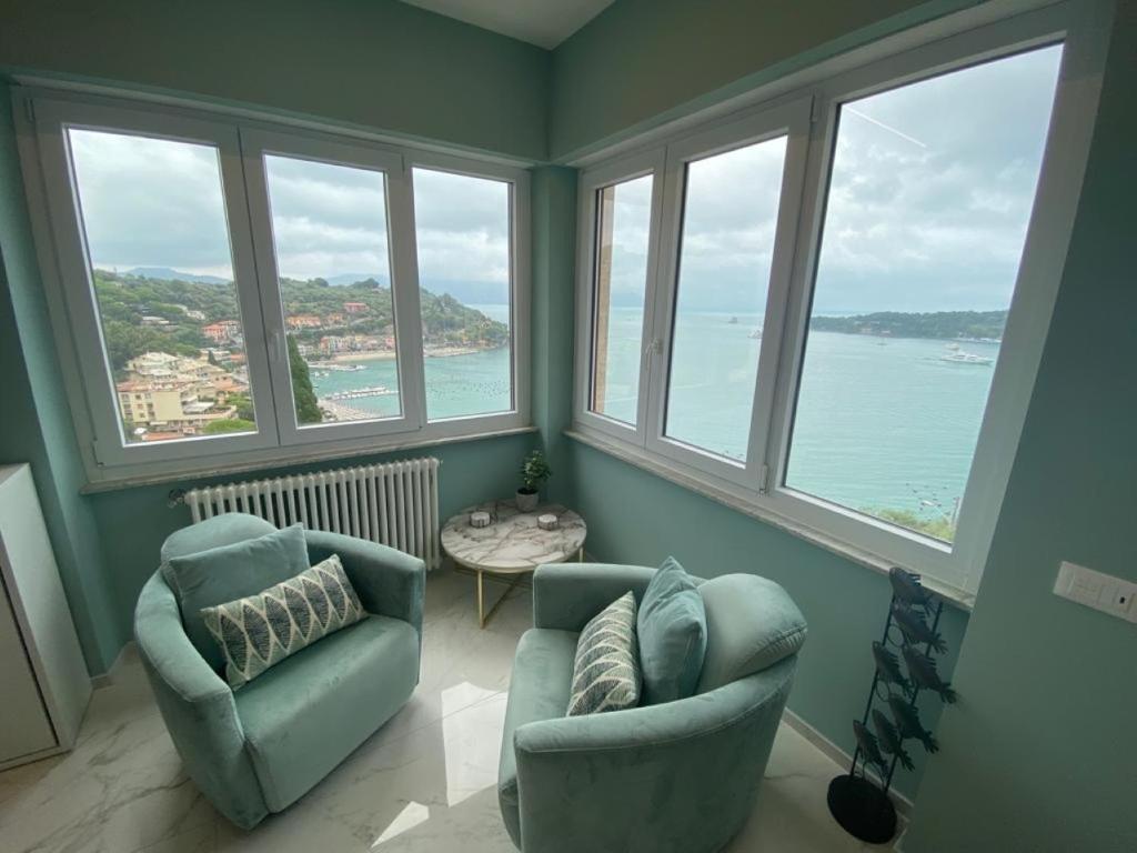 韦内雷港CaseMaggi Attico sul Mare, Penthouse on the Sea的客厅设有两把椅子和大窗户