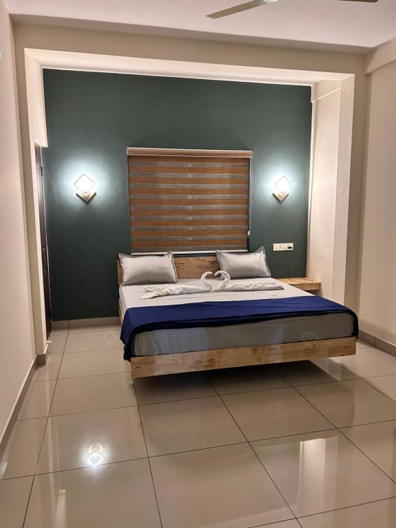 苏丹巴特利Sats residency的一间卧室配有一张大床和木制床头板