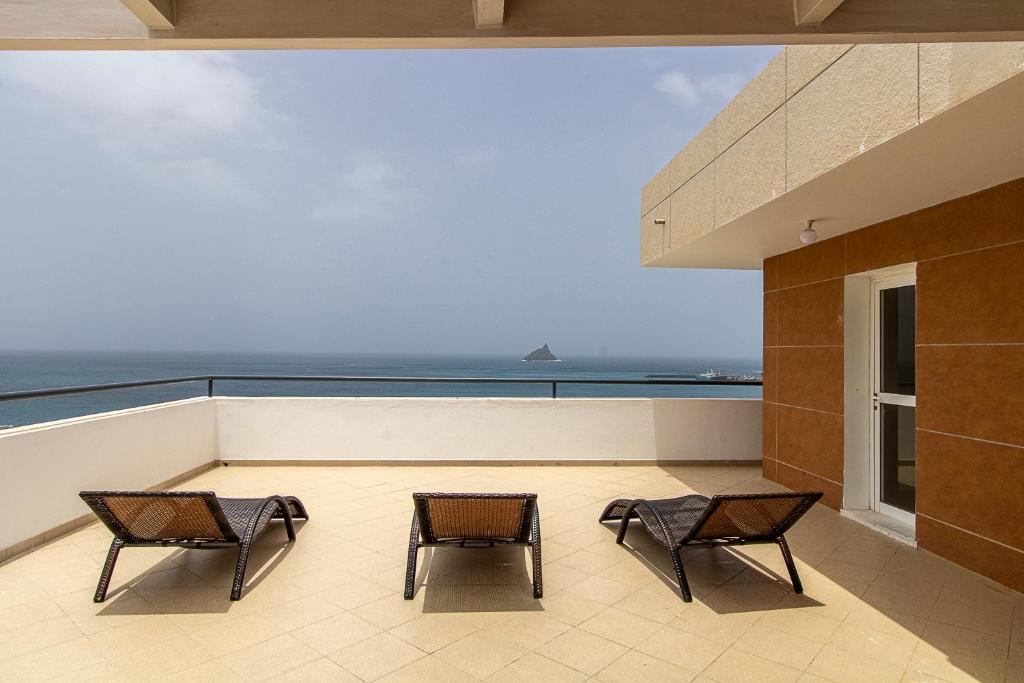 明德卢Sky Mariposa sospesa sul mare的阳台配有两把椅子,背靠大海
