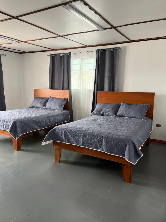 阿拉胡埃拉MARIO的一间卧室设有两张床和窗户。