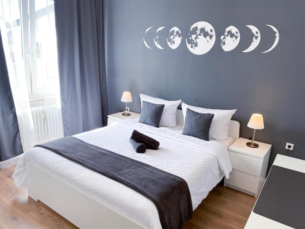 布吕尔NOVA Apartment- Phantasialand I Köln I Bonn的卧室配有白色大床和蓝色的墙壁