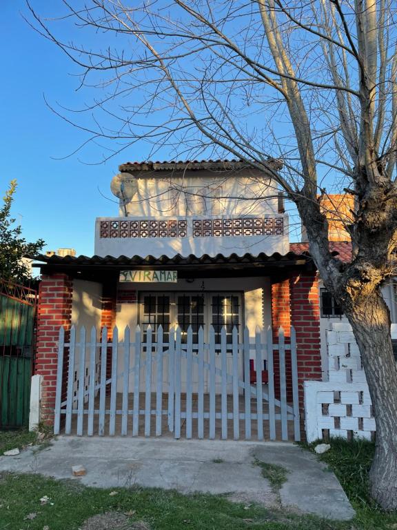 巴拉德尔楚VIRAMAR en Alvorada的白色栅栏的红砖房子