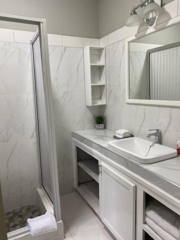 尼格瑞尔Runthings Hideaway Stay Negril的白色的浴室设有水槽和淋浴。