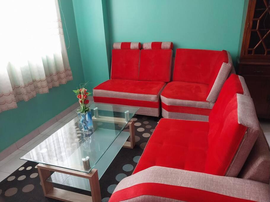 莫约班巴D202的客厅配有红色的沙发和桌子