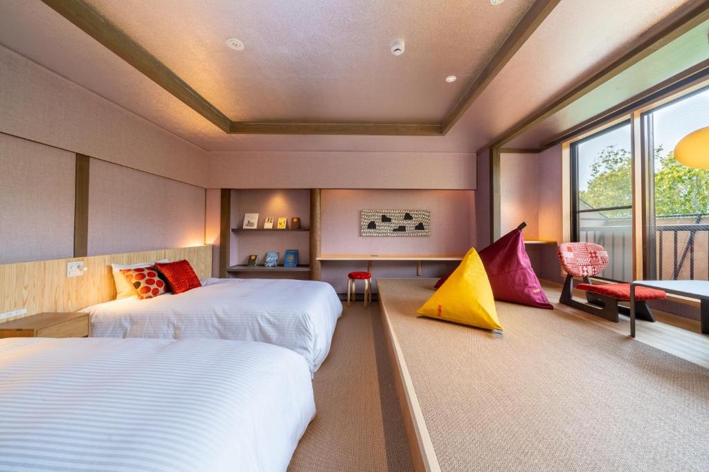 由布市伊诺吉亚日式旅馆的一间卧室设有两张床和窗户。