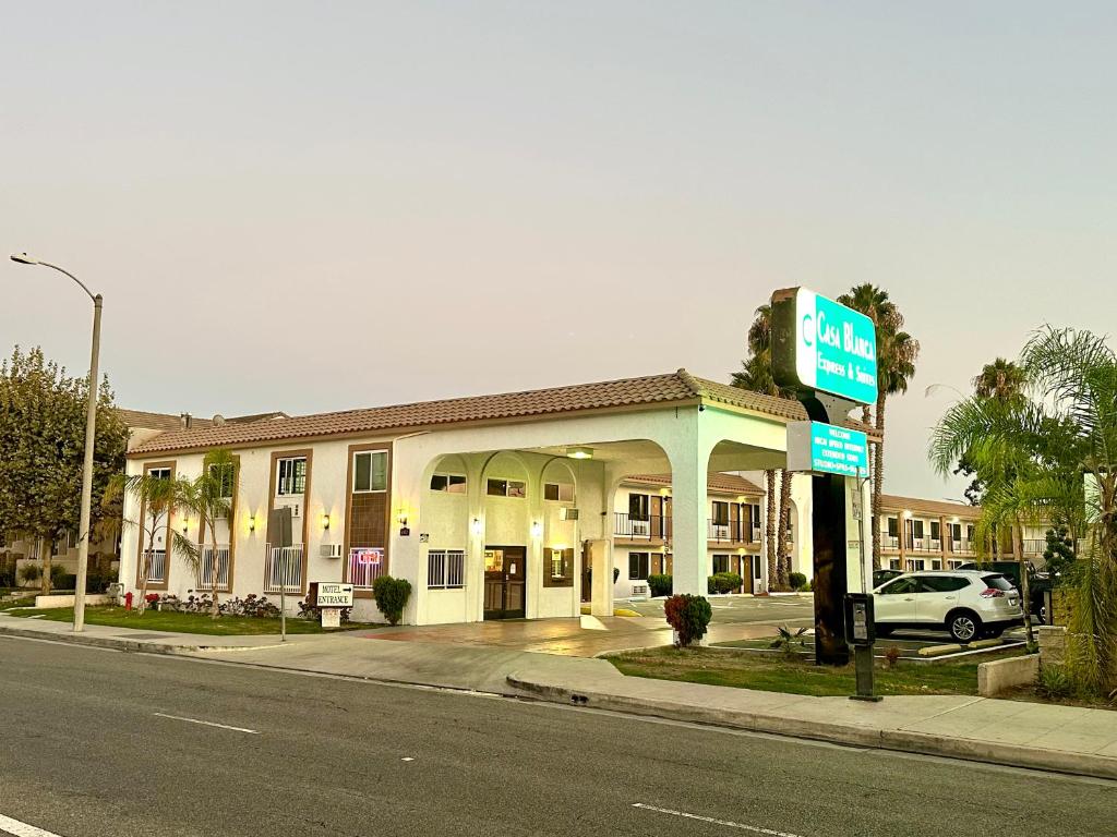 赛普里斯Casa Blanca Express & Suites Cypress Buena Park - Anaheim Area的街道边设有加油站的酒店