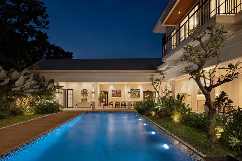 茂物Bincarung House Bogor的夜间房子后院的游泳池