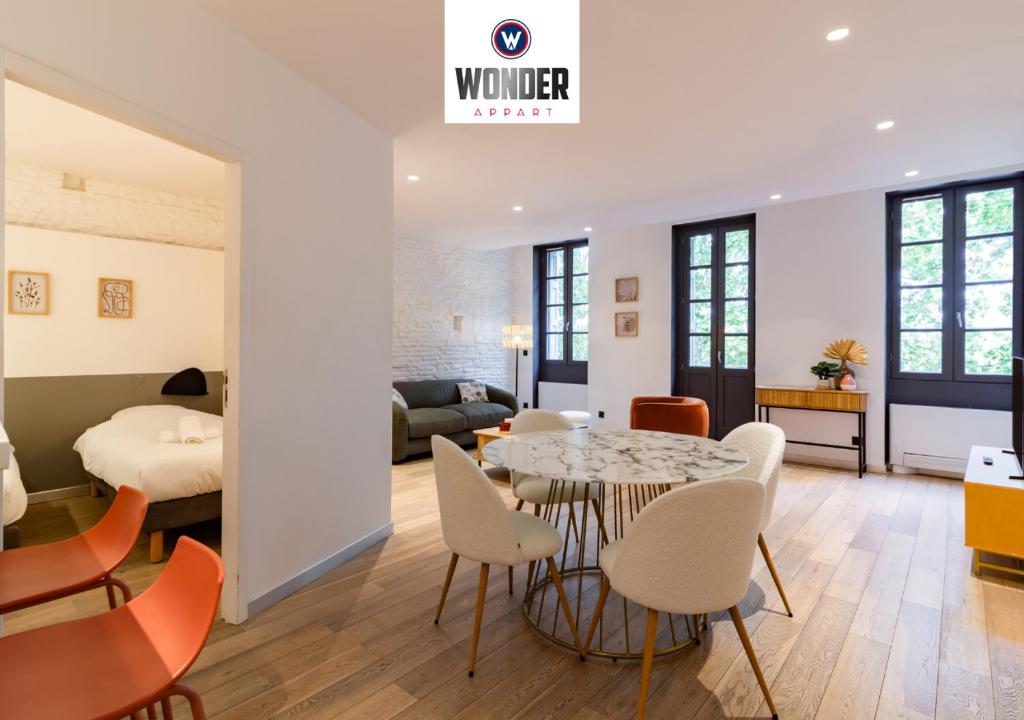 图卢兹404 · Wonder Appart - Vue Garonne -的一间带桌椅的房间和一间卧室