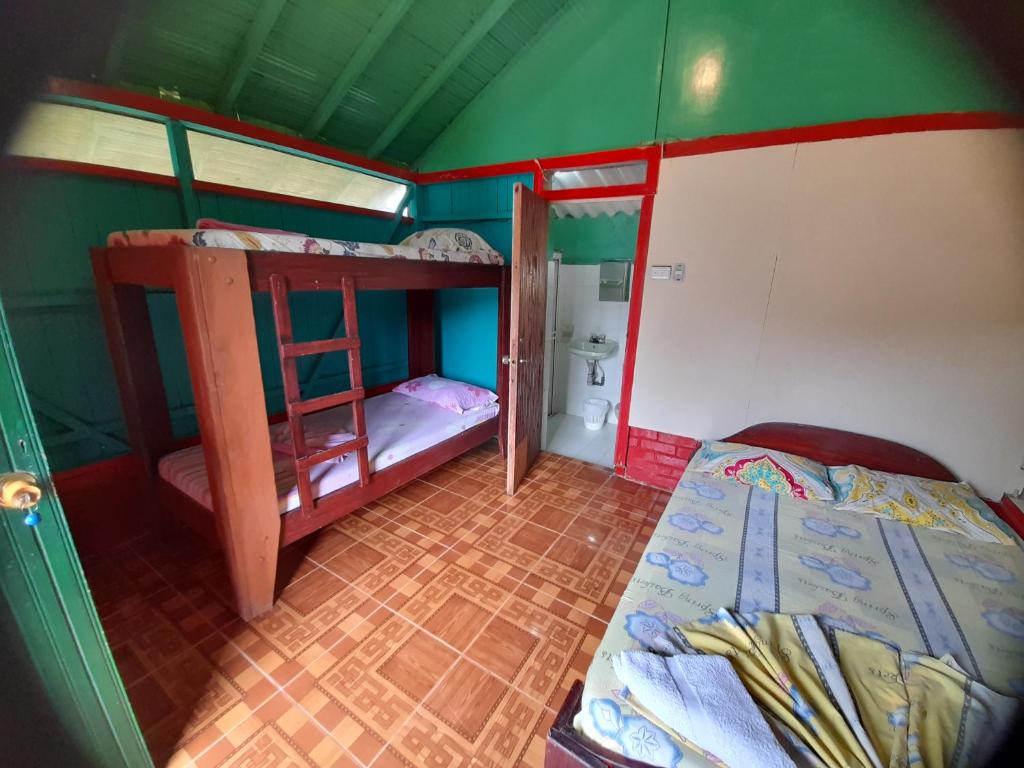 Playa LadrillerosCabaña Playa Ladrilleros的一间小房间,设有两张双层床和一间浴室