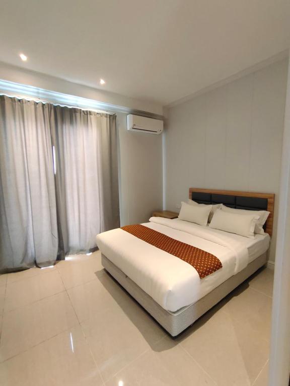 仙本那卡瑟卡瑟旅馆的卧室在窗户前配有一张白色大床