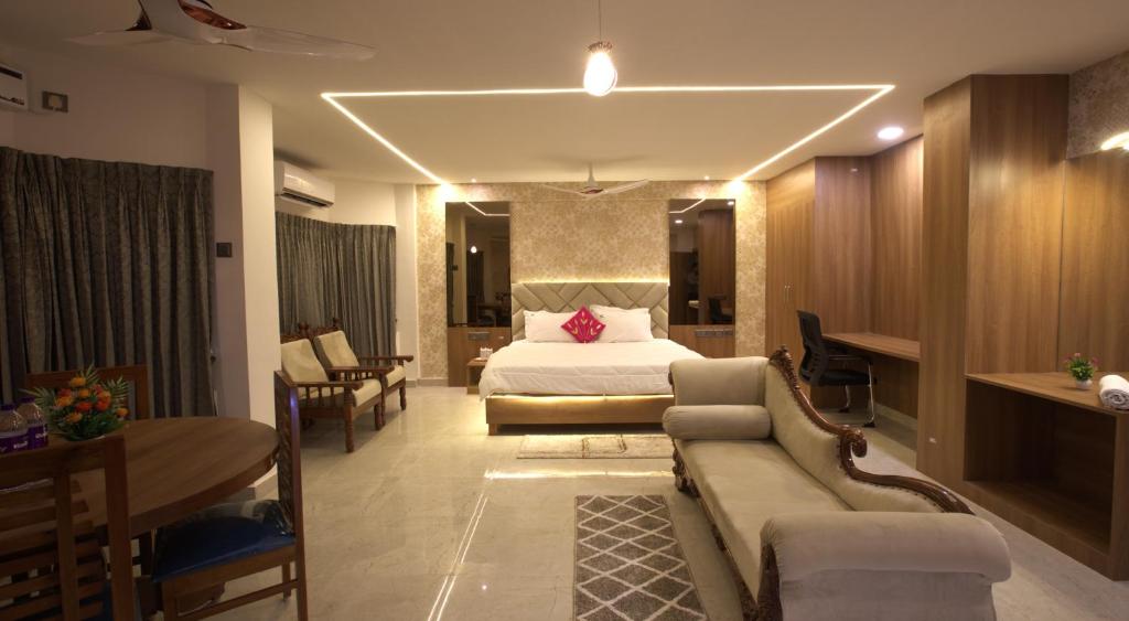 甘吉布勒姆Hotel TamilNadu, Kancheepuram的酒店客房配有床、沙发和桌子。