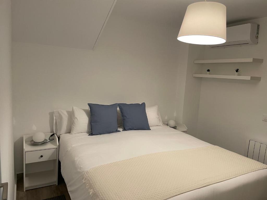 马德里C1 Madrid, Zona exclusiva的一间卧室配有白色床和蓝色枕头
