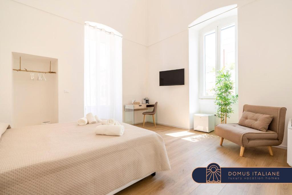 莫诺波利Casa Del Barone - Luxury Suites的白色卧室配有床和椅子
