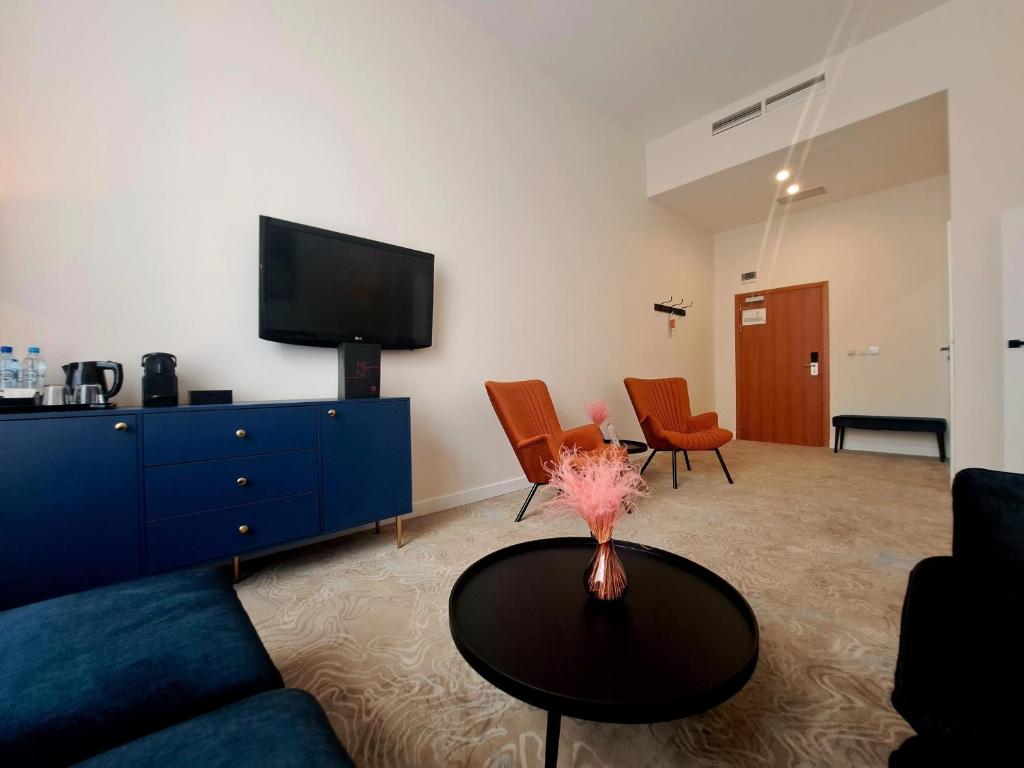 罗兹罗兹福克斯酒店的客厅配有蓝色的沙发和桌子