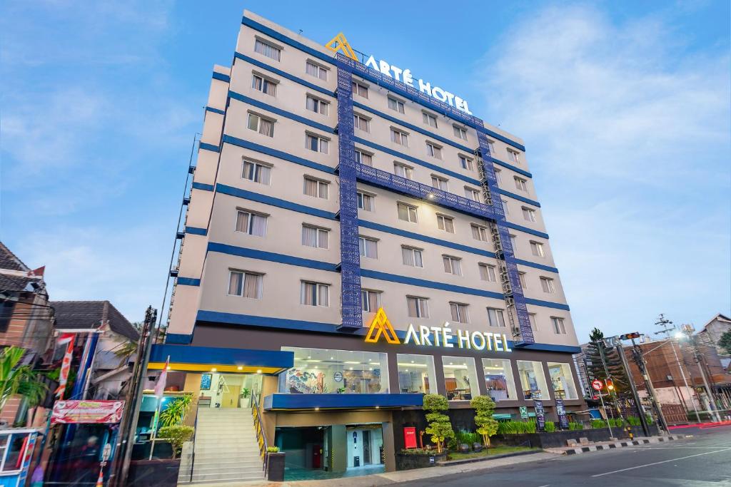 日惹Arte Hotel Yogyakarta的一间大型白色酒店,上面有酒店标志