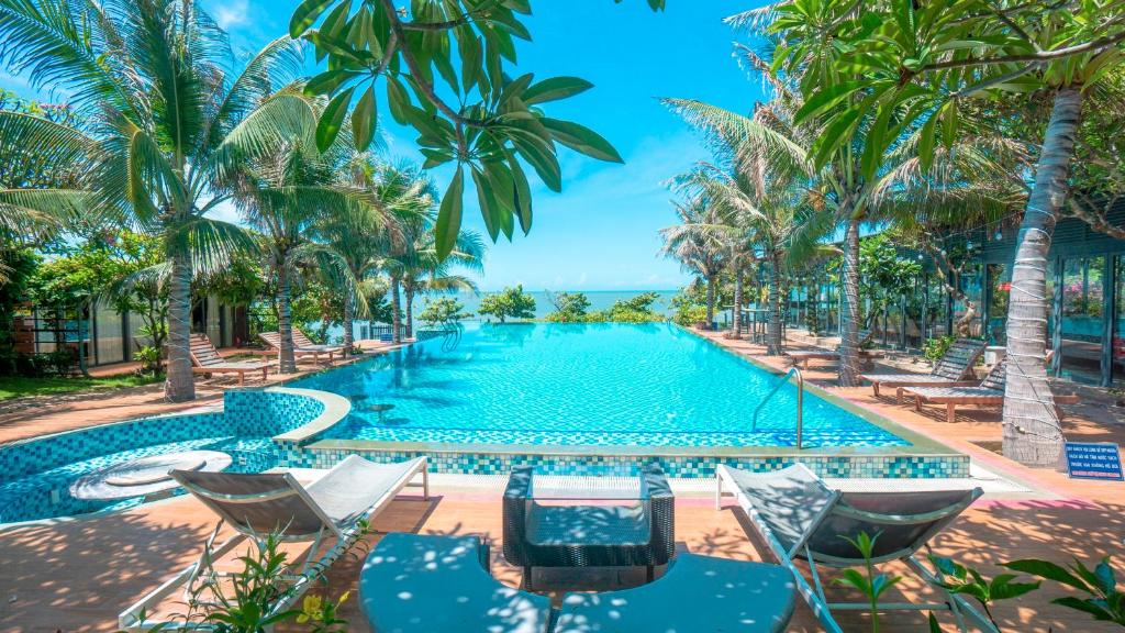 隆海安和公寓酒店的一个带椅子的游泳池,棕榈树