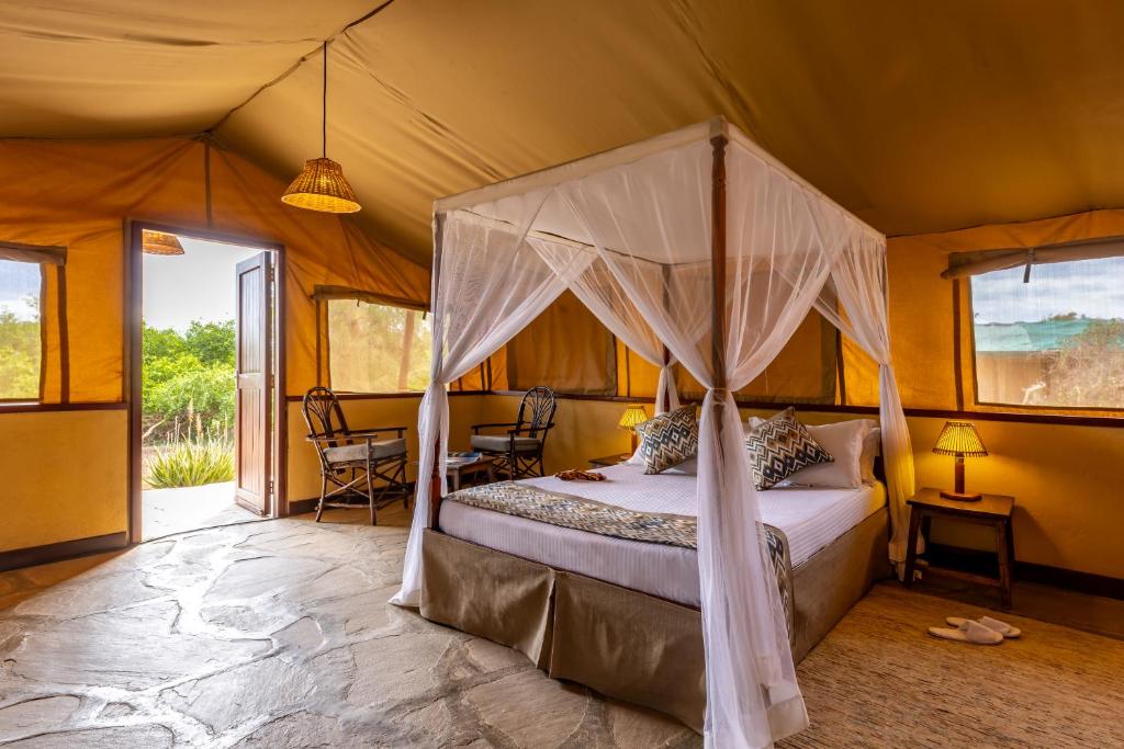 TsavoSentrim Tsavo Lodge的一间帐篷内带天蓬床的卧室