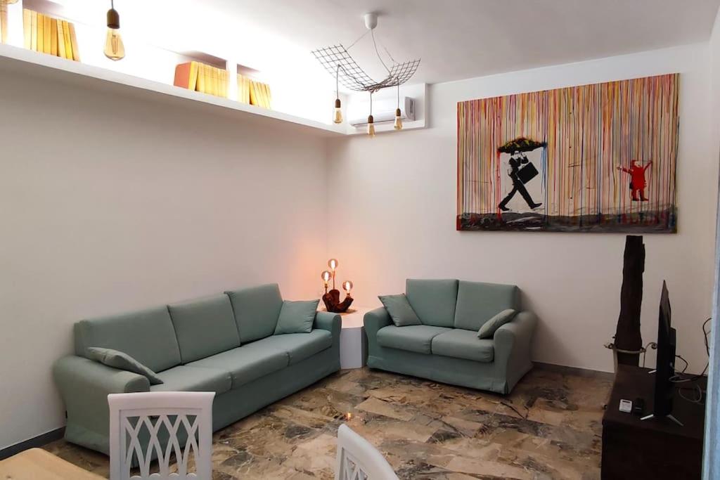 丽都迪奥斯蒂亚Sunnyhome- Ostia Lido vista mare 2 bagni的客厅配有两张绿色沙发和一幅画