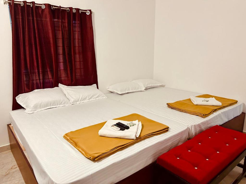 蓬蒂切里DE Villa Breeze @ Beach side的一张带两条毛巾和红椅的白色床